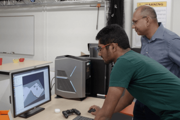 Srivastava (right) and Nagpal observe Alfred’s efforts to plan the route it will take to successfully clear dishes off a table without any programming done in advance about the working area.