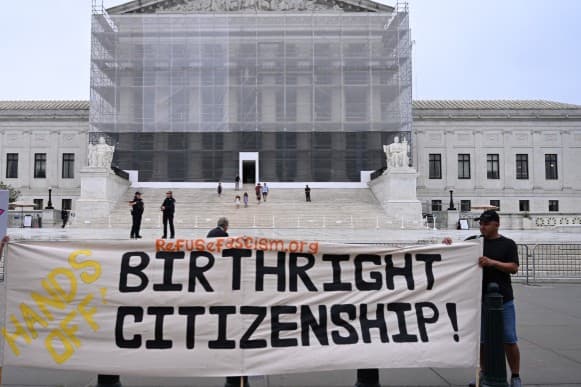Demonstrators hold signs outside the U.S. Supreme Court building on the day the court is expected to hear oral arguments on the legality of the Trump administration's effort to limit birthright citizenship for the children of immigrants, in Washington, D.C., U.S., April 1, 2026.