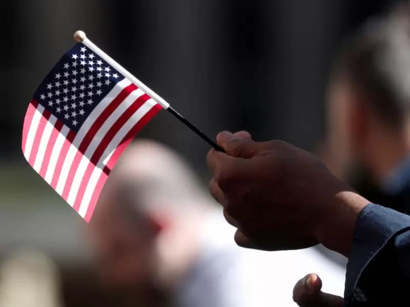 A citizenship candidate holds a flag during the U.S. Citizenship and Immigration Services (USCIS) naturalization ceremony at Rockefeller Plaza in New York City, U.S., September 17, 2019.