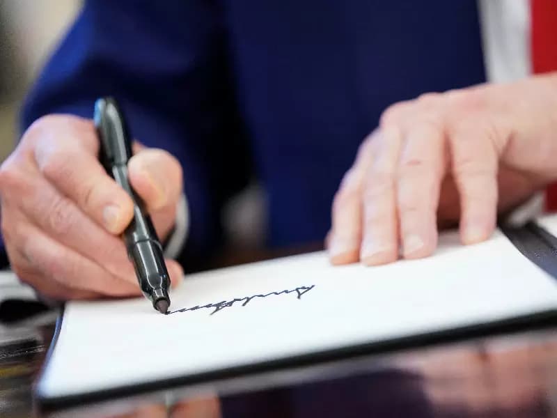 U.S. President Donald Trump writes his signature, as he signs executive orders and proclamations in the Oval Office at the White House in Washington, D.C., U.S., April 9, 2025.