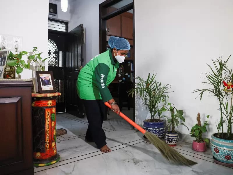 Laxmi, an employee with Pronto cleans a house with a broom in New Delhi, India, March 23, 2026.