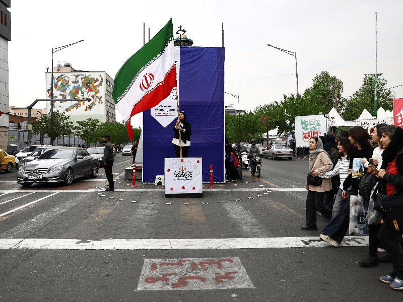 A woman holds an Iranian flag on a street, amid a ceasefire between U.S. and Iran, in Tehran, Iran, April 20, 2026.
