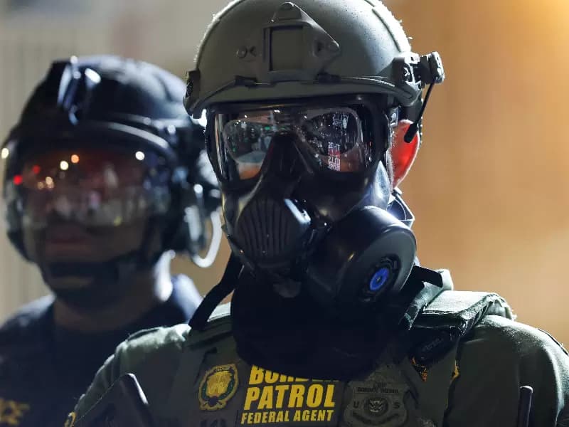 FILE PHOTO: A Border Patrol agent stands guard as people gather outside the U.S. Immigration and Customs Enforcement (ICE) facility, in Portland, Oregon, March 28, 2026.