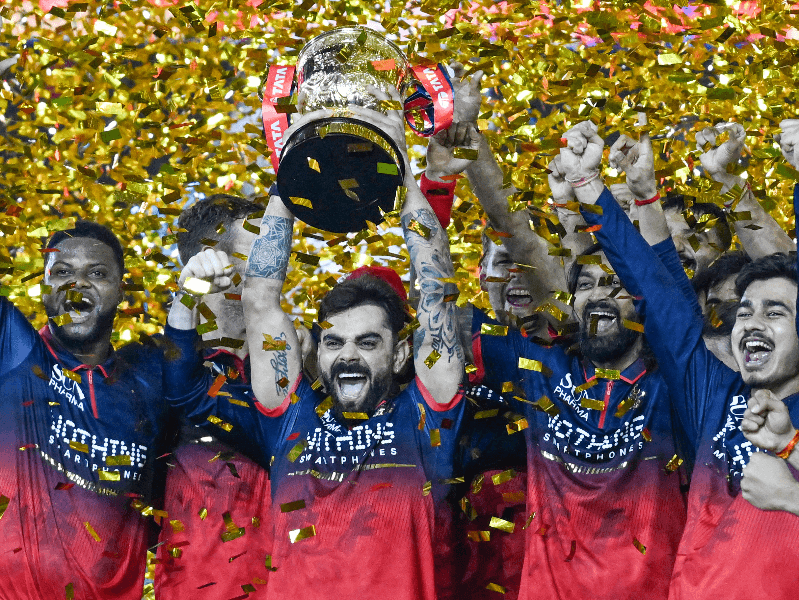Royal Challengers Bengaluru's players celebrate with the trophy after winning the Indian Premier League (IPL) 2026 in Ahmedabad, Gujarat, on Monday, June 1, 2026
